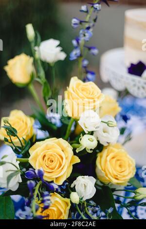 Bouquet de mariage vibrant de roses jaunes et blanches avec marine touches bleues Banque D'Images