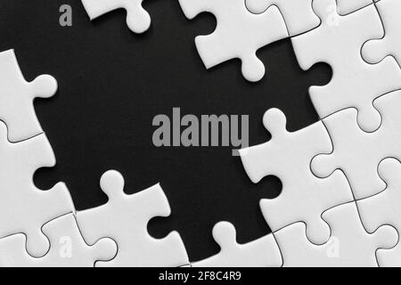 Puzzle blanc inachevé sur fond noir Banque D'Images