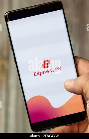 Un téléphone mobile ou mobile détenu par un Main avec l'application Express VPN ouverte à l'écran Banque D'Images