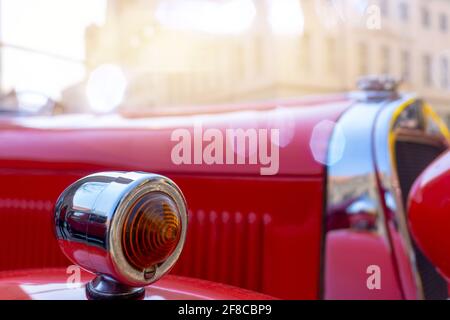 Un indicateur d'une voiture vintage rouge, délibérément flous dans l'arrière-plan flou, Banque D'Images