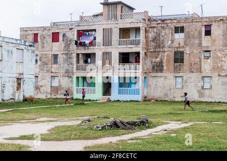 GIBARA, CUBA - 29 JANVIER 2016 : les enfants jouent au baseball devant des blocs d'appartements en béton dilatés dans le village de Gibara, Cuba Banque D'Images