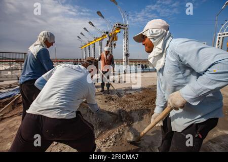 Kazakhstan, barrage de stockage d'eau de Shardara. Groupe de travailleurs ouzbek mélangeant le béton manuellement. Rénovation de la route et du pont. Banque D'Images