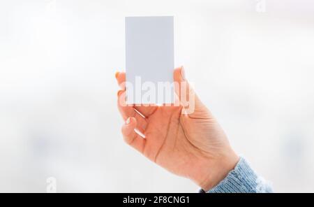 Carte de visite blanche vierge dans la main de la femme Banque D'Images