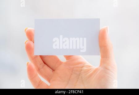 Main tenant une carte de visite blanche vide Banque D'Images