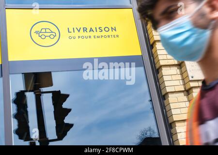 Montréal, Canada - 11 avril 2021 : affiche livraise ou pour transporter en français (livraison ou nourriture à emporter) affichée sur la fenêtre d'un restaurant durin Banque D'Images