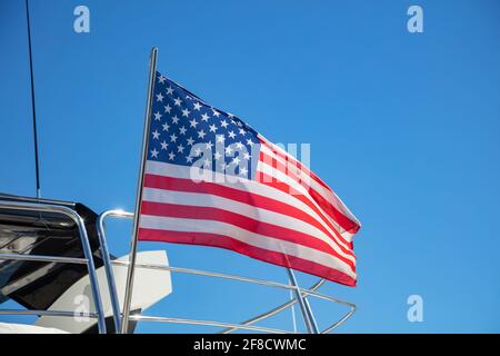 Drapeau des États-Unis d'Amérique agitant sur la poupe de yacht. Bateau de luxe amarré à la marina d'Athènes en Grèce. Fond bleu ciel, vue rapprochée. Banque D'Images