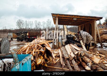 bois sur le convoyeur. les gens travaillent sur une scierie automatisée. entreprise industrielle pour la transformation du bois. le travailleur met les planches dans la croishe Banque D'Images