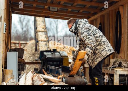 bois sur le convoyeur. les gens travaillent sur une scierie automatisée. entreprise industrielle pour la transformation du bois. le travailleur met les planches dans la croishe Banque D'Images