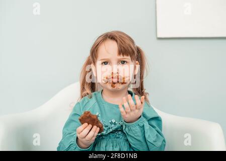 Adorable petite fille au visage recouvert de chocolat Banque D'Images