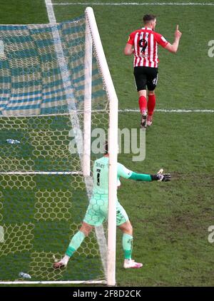 Charlie Wyke de Sunderland (haut de la page) célèbre le premier but du match de son côté alors que Jamie Jones, gardien de but de Wigan Athletic, réagit lors du match Sky Bet League One au stade DW, à Wigan. Date de la photo: Mardi 13 avril 2021. Banque D'Images