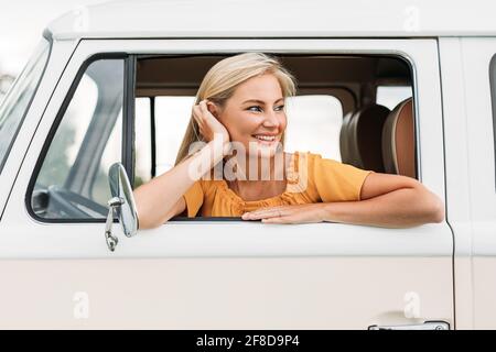 Belle jeune femme regardant hors de la voiture en appréciant un super séjour Banque D'Images