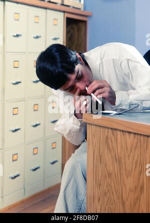 Un jeune homme blanc ronflant de la cocaïne sur la ruse au bureau. ©Bob Daemmrich Banque D'Images