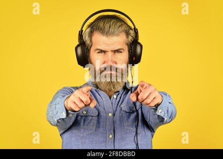 essayez. Écouter de la musique. Il est temps de se détendre. Brutales vêtements hipster porter des écouteurs. Chant et danse. Profiter de sa musique préférée. Homme écoutant de la musique avec Banque D'Images