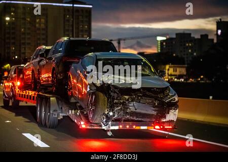 Chargé une voiture brisée sur un camion de remorquage après un accident la nuit Banque D'Images