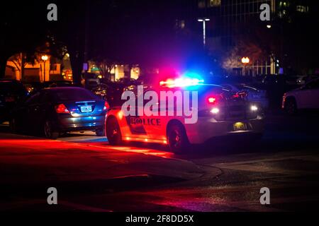 Voiture de police avec feux de détresse qui clignotent la nuit en ville de l'arrière Banque D'Images
