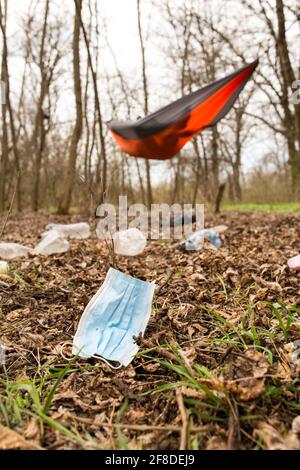 Utilisé masque médical avec bouteilles de plastick dans la zone de camping, sur la forêt sauvage. Banque D'Images