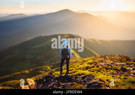 Fille sur le pic de montagne avec regarder la belle vallée de montagne Banque D'Images