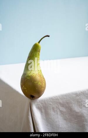 conférence de poire verte fraîche isolée sur table blanche et fond bleu. Banque D'Images
