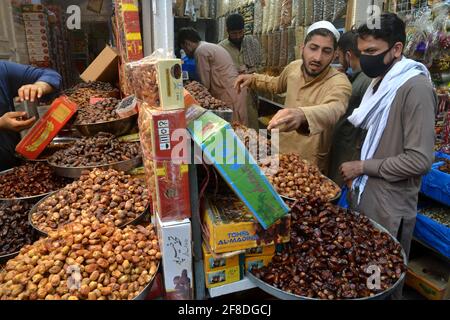 Peshawar. 13 avril 2021. Les gens achètent des dates sur un marché avant le mois de jeûne du Ramadan, dans le nord-ouest du Pakistan, à Peshawar, le 13 avril 2021. Le croissant de lune du Ramadan a été aperçu au Pakistan mardi soir et le mois Saint commencera officiellement mercredi, selon une annonce officielle du comité d'observation de la lune du pays. Credit: Umar Qayyum/Xinhua/Alamy Live News Banque D'Images