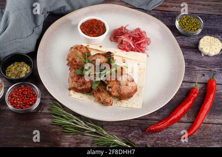 Shish kebab sur une assiette. Sur une table en bois sombre. Vue du dessus Banque D'Images