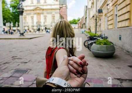 Voyage dans la ville célèbre Suivez-moi femme dans une ville européenne tenant la main de petit ami ou de mari après la marche de la principale petite amie. Tourisme, amour, ho Banque D'Images