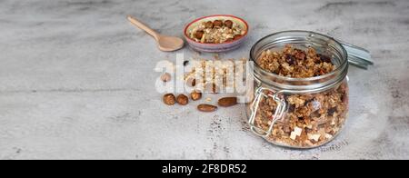 En-tête d'une granola maison avec des fruits secs, du chocolat, des noix et des flocons d'avoine dans un pot de maçon Banque D'Images