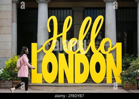 Londres, Royaume-Uni. 13 avril 2021. Une femme passe devant le panneau jaune Hello London à Covent Garden Market. Crédit: Waldemar Sikora Banque D'Images