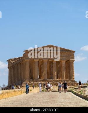 Touristes marchant dans Vell dei Templi avec le Temple de Concordia en arrière-plan Banque D'Images