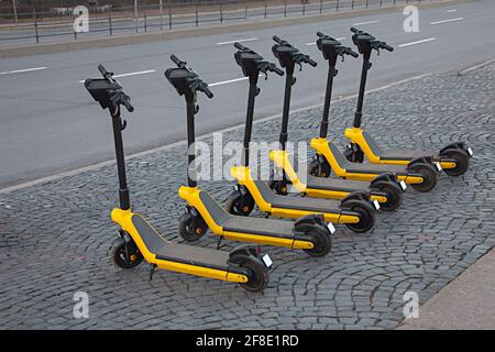 Location de scooters électriques garés dans les rues de la ville, transport écologique, véhicule économique, partage Banque D'Images