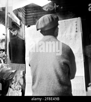 Chinois Homme lisant des nouvelles de la capitulation de Canton aux Japonais, Chinatown, San Francisco, Californie, Etats-Unis, Dorothea Lange, Bureau américain d'information sur la guerre, novembre 1938 Banque D'Images