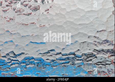 détail d'un verre translucide avec des gravures reflétant l'arrière-plan couleurs Banque D'Images