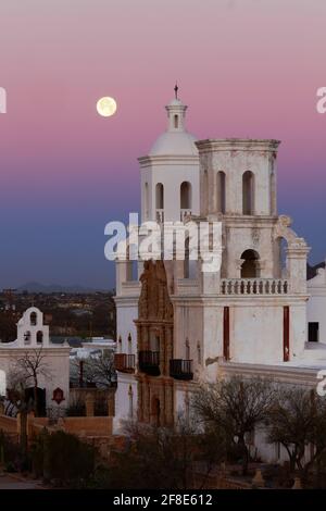 Tohono O'odham Indian Reservation AZ / JAN Lune d'hiver à l'aube au-dessus de la mission San Xavier del bac. Banque D'Images