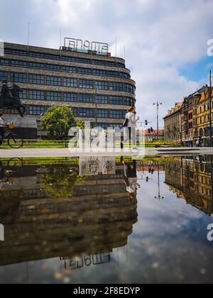 Wroclaw, Pologne - juin 25 2020 : centre commercial Renoma avec statue de Boleslaw Chrombry et personnes à pied reflétées dans la flaque par temps nuageux Banque D'Images