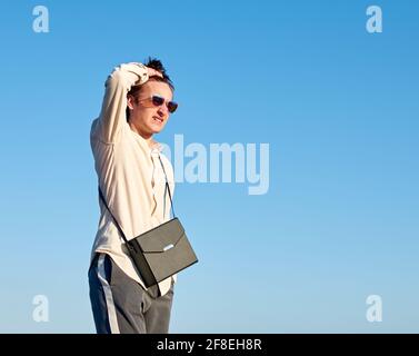 Vertical d'un jeune espagnol élégant homme beau debout contre le ciel bleu Banque D'Images