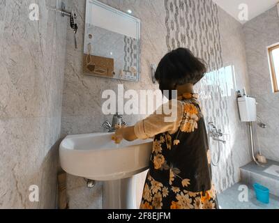 Enfants masqués se laver les mains pendant une pandémie de coronavirus. Le port et l'utilisation d'assainisseur du masque de lavage des mains sont recommandés par l'organisation mondiale de la santé. Banque D'Images