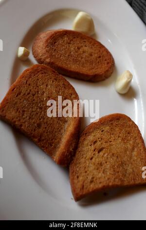 Toasts à l'ail sur une assiette blanche au restaurant Banque D'Images