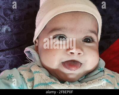 Magnifique enfant différentes poses semble très beau. Les petits enfants après leur naissance ont des joues douces et un petit visage innocent avec un sourire criant. Banque D'Images