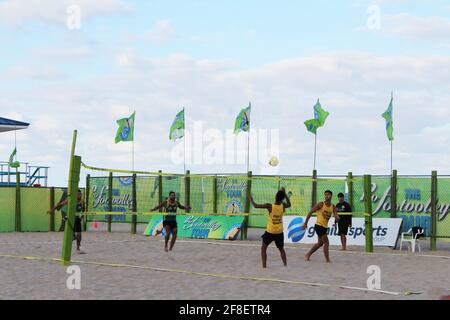 Groupe de personnes jouant à un jeu appelé Footvolley sur le sable de la plage près de l'océan dans le sud de la floride pendant la pandémie COVID-19. Banque D'Images