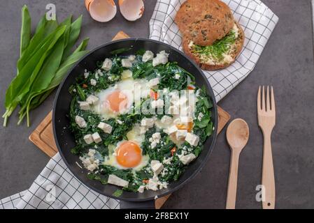 Shakshuka vert. Œufs frits à l'ail sauvage et au fromage feta Banque D'Images