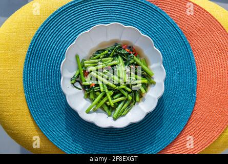 Sautés chinois matin Glory ou eau épineuse (pak boong fai daeng) assaisonnée de sauce Chili et soja sur une assiette blanche. Cuisine asiatique, sélective Banque D'Images