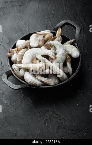 Carapace surgelée sur les crevettes tigrées ou crevettes tigrées asiatiques, dans une poêle à frire en fonte, sur fond de pierre noire, avec espace pour le texte Banque D'Images