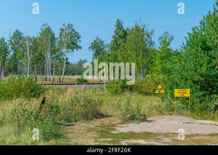 Signe jaune marquant les matières radioactives enfouies dans la zone d'exclusion de Tchernobyl En Ukraine Banque D'Images