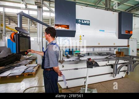 Aktau, Kazakhstan. Jeune opérateur programmant la machine CNC LVD. Production d'équipements électriques spéciaux. RIG Ltd Banque D'Images