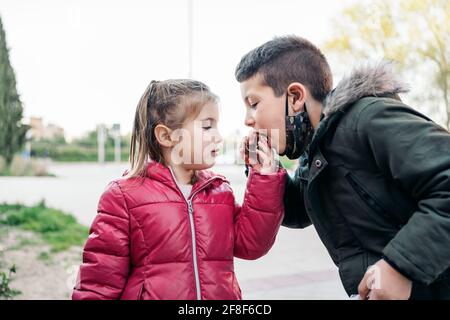 Portrait de deux enfants tout en mangeant et en partageant un morceau de chocolat Banque D'Images