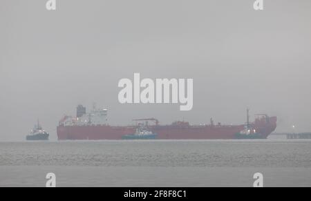 WhiteGate, Cork, Irlande. 14 avril 2021. Le pétrolier Gijon Knutsen est escorté par des remorqueurs Titan, Alex et Gerry O'Sullivan alors qu'elle effectue ses dernières manœuvres pour s'amarre dans un brouillard épais à la raffinerie de pétrole de Whitsgate à COK, en Irlande. - crédit; David Creedon / Alamy Live News Banque D'Images