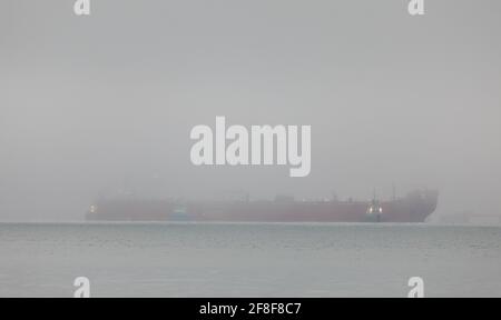 WhiteGate, Cork, Irlande. 14 avril 2021. Le pétrolier Gijon Knutsen est escorté par des remorqueurs Titan, Alex et Gerry O'Sullivan alors qu'elle effectue ses dernières manœuvres pour s'amarre dans un brouillard épais à la raffinerie de pétrole de Whitsgate à COK, en Irlande. - crédit; David Creedon / Alamy Live News Banque D'Images