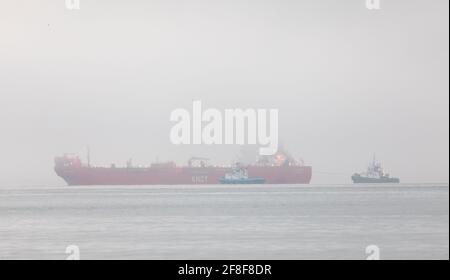 WhiteGate, Cork, Irlande. 14 avril 2021. Le pétrolier Gijon Knutsen est escorté par des remorqueurs Titan, Alex et Gerry O'Sullivan alors qu'elle effectue ses dernières manœuvres pour s'amarre dans un brouillard épais à la raffinerie de pétrole de Whitsgate à COK, en Irlande. - crédit; David Creedon / Alamy Live News Banque D'Images