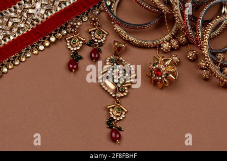 Bijoux anciens sur fond marron, foulard doré, bracelet or, collier or, boucles d'oreilles or, porte-doigts bijoux traditionnels indiens Banque D'Images