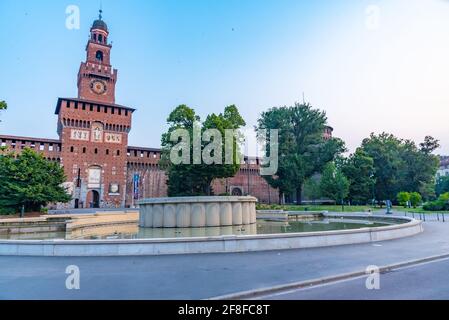 Vue au lever du soleil sur une fontaine en face du Castello Sforzesco à Milan, en Italie Banque D'Images