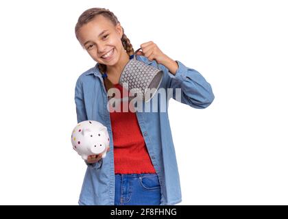 Belle adolescente tient une banque de porc dans ses mains, isolée sur fond blanc Banque D'Images